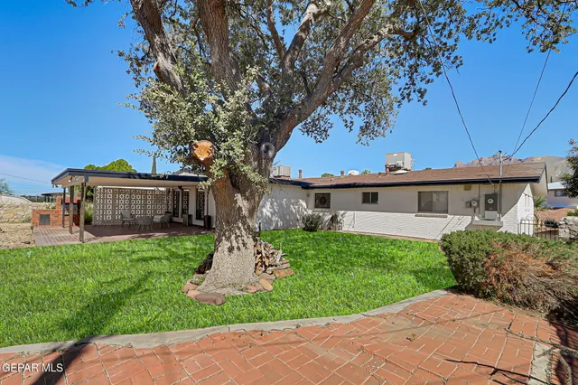 a view of a house with backyard sitting area and garden