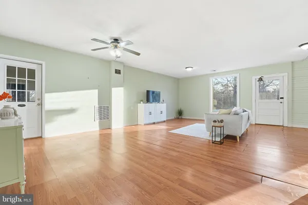 a living room with furniture and a wooden floor