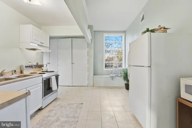 a kitchen with a refrigerator a sink and a stove top oven