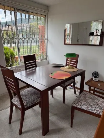 a view of a dining room with furniture and a potted plant