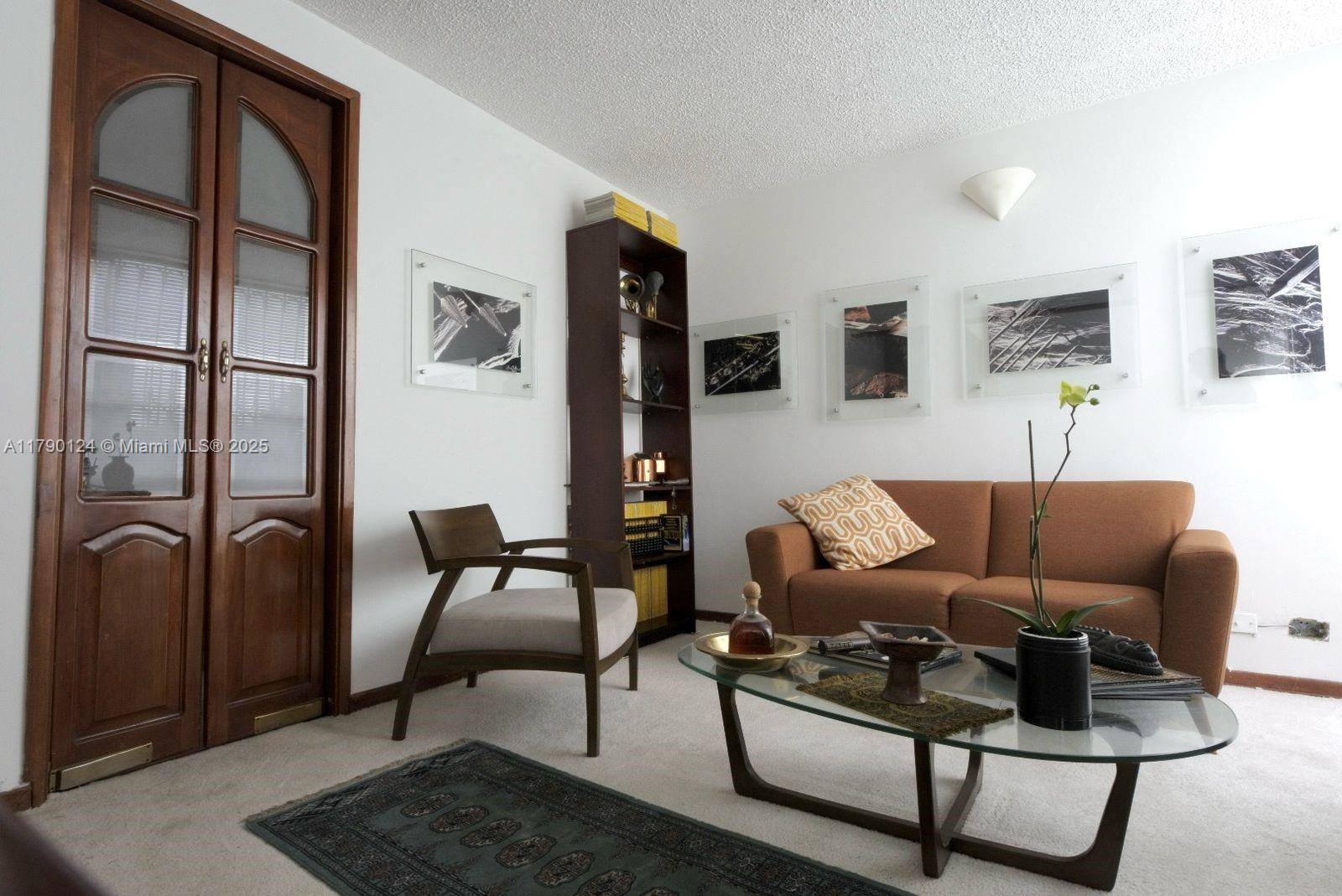174-8-90 Calle Queens, FL 11101 - Photo 7 of 16 a living room with furniture and a rug