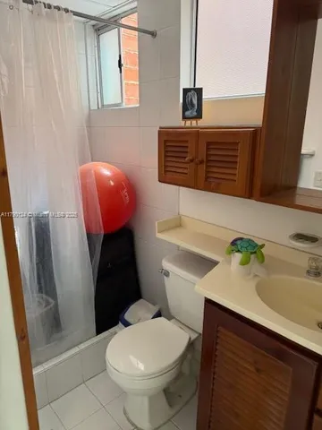a bathroom with a granite countertop toilet sink and mirror