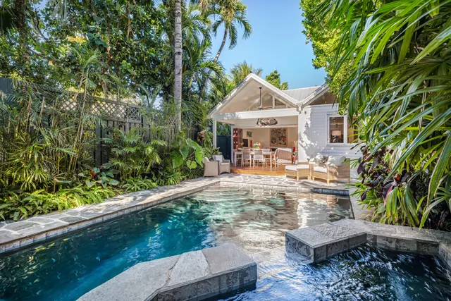 a view of a house with pool and sitting area