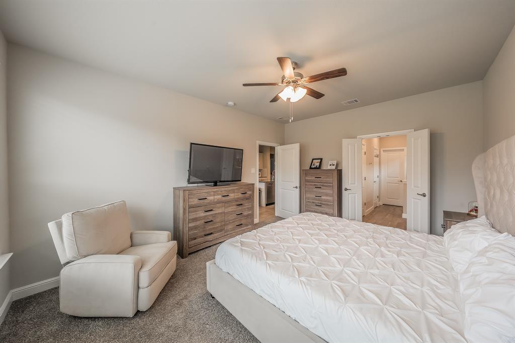 1212 Bosque Lane Weatherford, TX 76087 - Photo 26 of 38 a spacious bedroom with a bed a couch and a flat screen tv