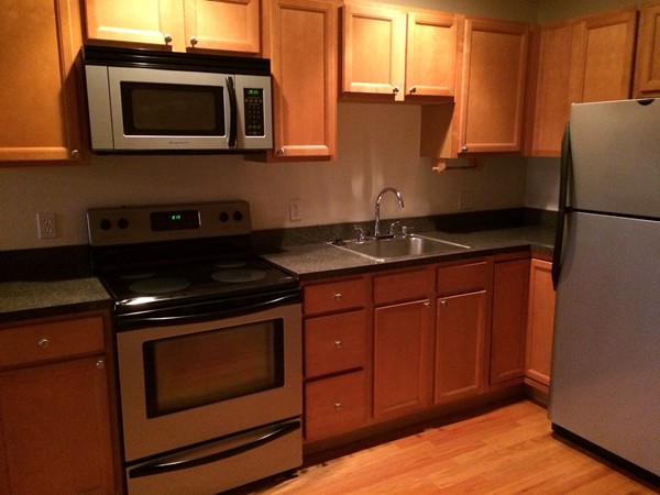 160 Cottage Street, Unit 302 Boston, MA 02128 - Photo 4 of 18 a kitchen with stainless steel appliances granite countertop a stove microwave and sink