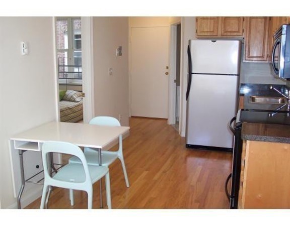 160 Cottage Street, Unit 302 Boston, MA 02128 - Photo 5 of 18 a kitchen with stainless steel appliances refrigerator dining table and chairs