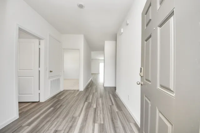 a view of a room with wooden floor and entryway