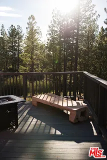 a roof deck with chairs and wooden fence