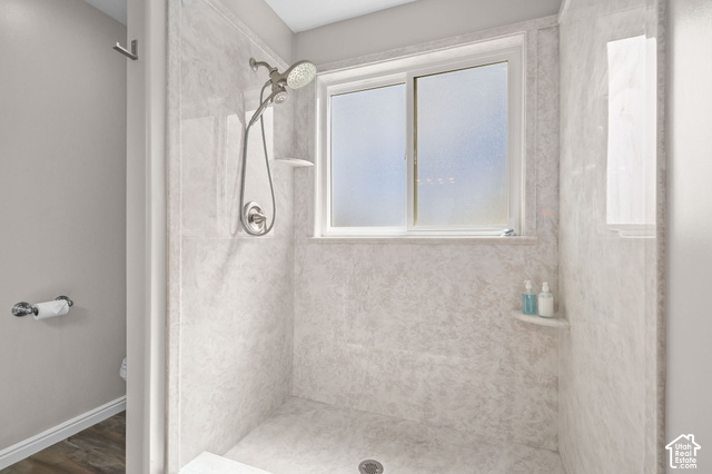1045 West 3600th South Perry, UT 84302 - Photo 24 of 57 Shower enclosure with light-toned wall panels, a built-in corner shelf, and a sliding window