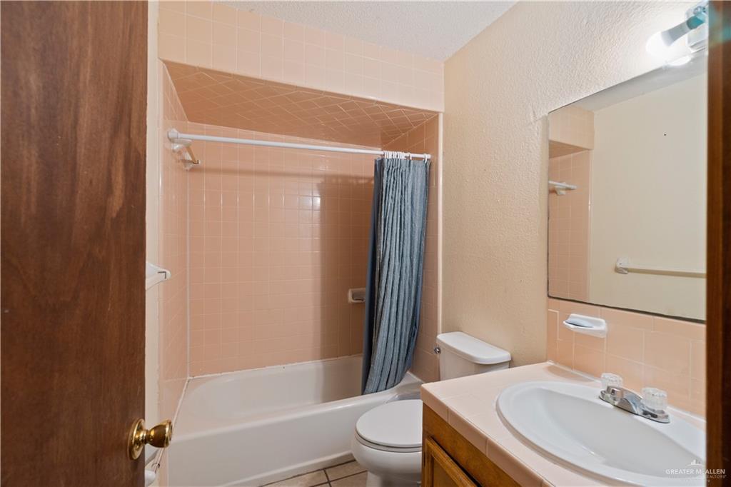 106 Rosa Priego Street Donna, TX 78537 - Photo 11 of 25 Full bathroom with toilet, vanity, shower / bathtub combination with curtain, and tile patterned flooring