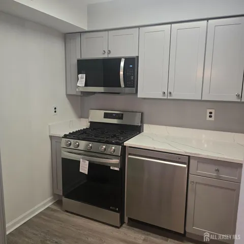 a kitchen with stainless steel appliances granite countertop a stove and a microwave