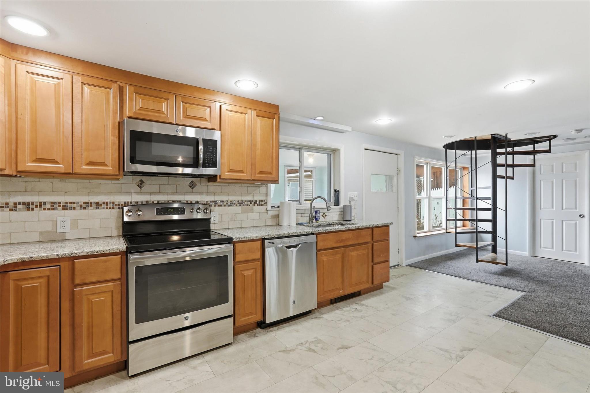 337 Main Street Tullytown, PA 19007 - Photo 9 of 33 a kitchen with stainless steel appliances granite countertop a stove top oven a sink and a microwave