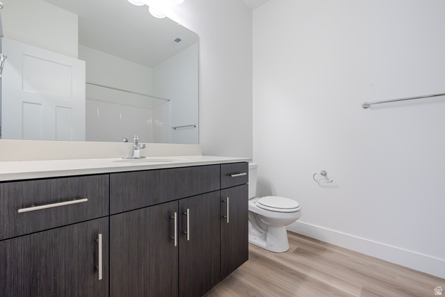 Modern bathroom featuring a vanity with dark wood-finish cabinetry, a light-toned countertop, and an integrated sink