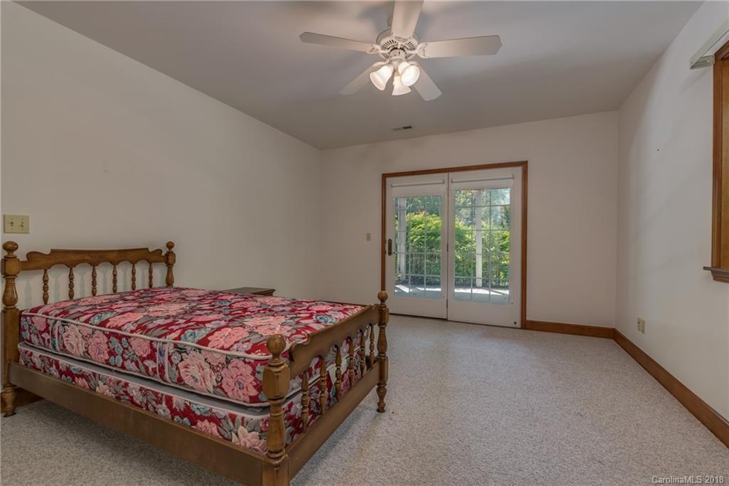 661 Henderson Road Tryon, NC 28782 - Photo 19 of 33 a bedroom with a bed chandelier and a window