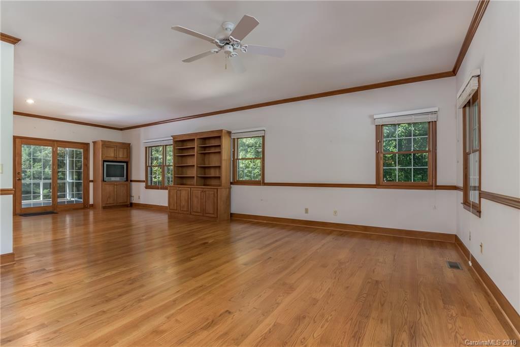 661 Henderson Road Tryon, NC 28782 - Photo 7 of 33 an empty room with wooden floor and windows