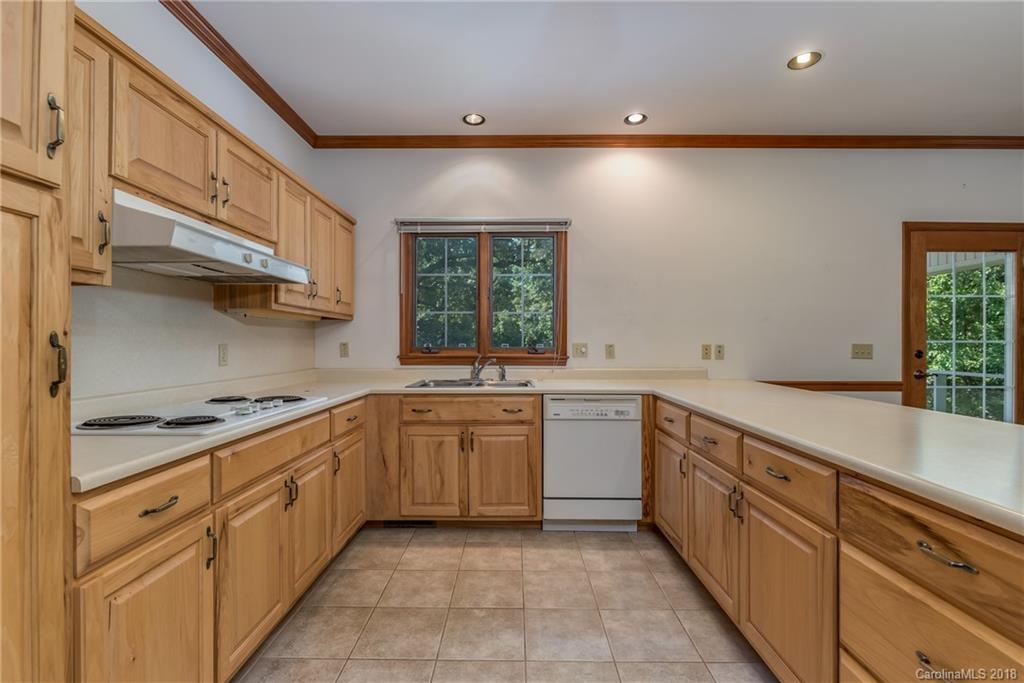 661 Henderson Road Tryon, NC 28782 - Photo 9 of 33 a large kitchen with stainless steel appliances granite countertop a sink and dishwasher a stove top oven with wooden floor