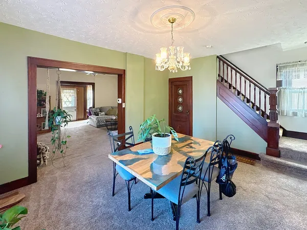 a view of a dining room with furniture and a chandelier