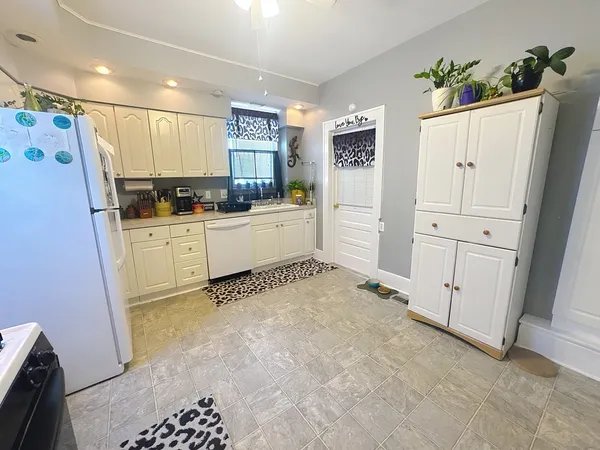 a kitchen with white cabinets and white appliances