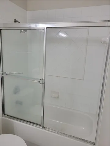 a bathroom with a shower and a glass door