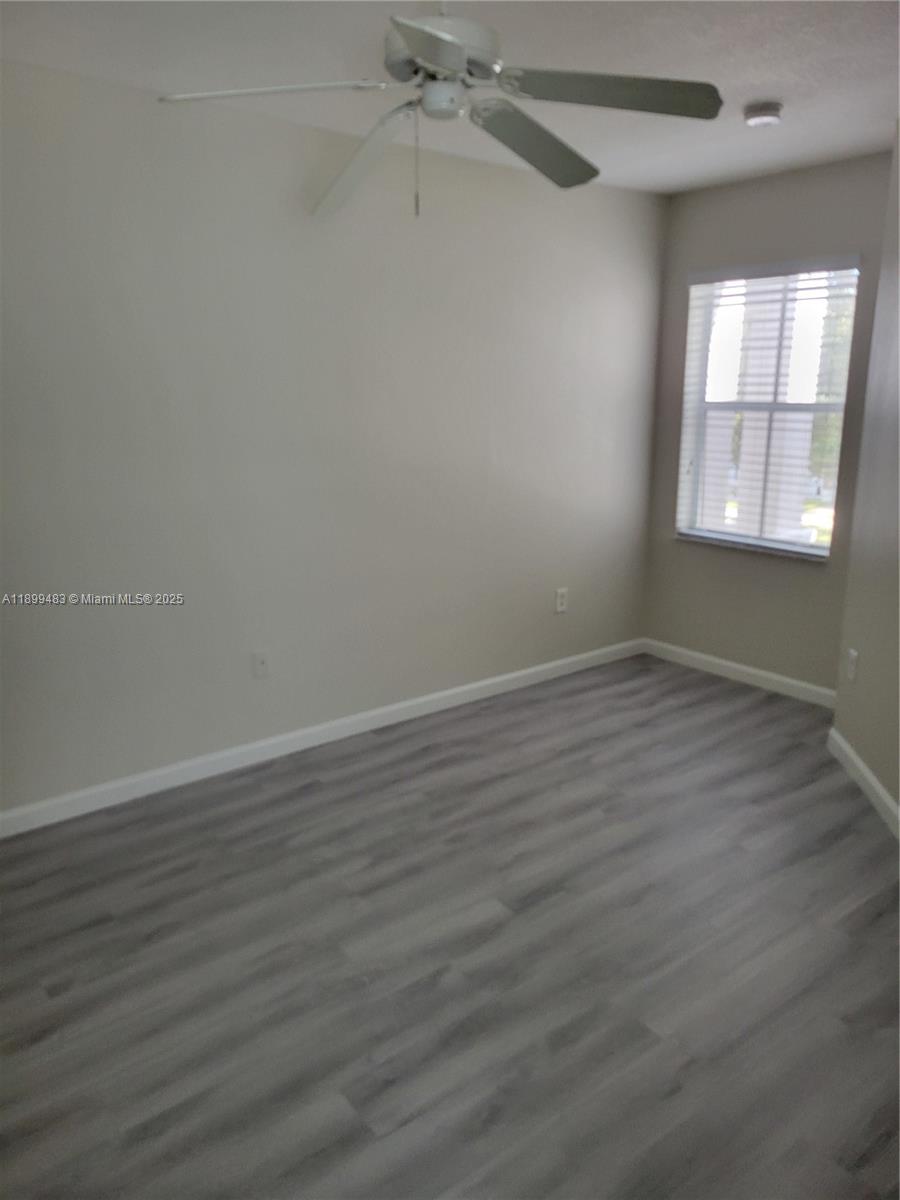 2556 Southwest 83rd Avenue, Unit 101 Miramar, FL 33025 - Photo 16 of 19 wooden floor in an empty room with a window