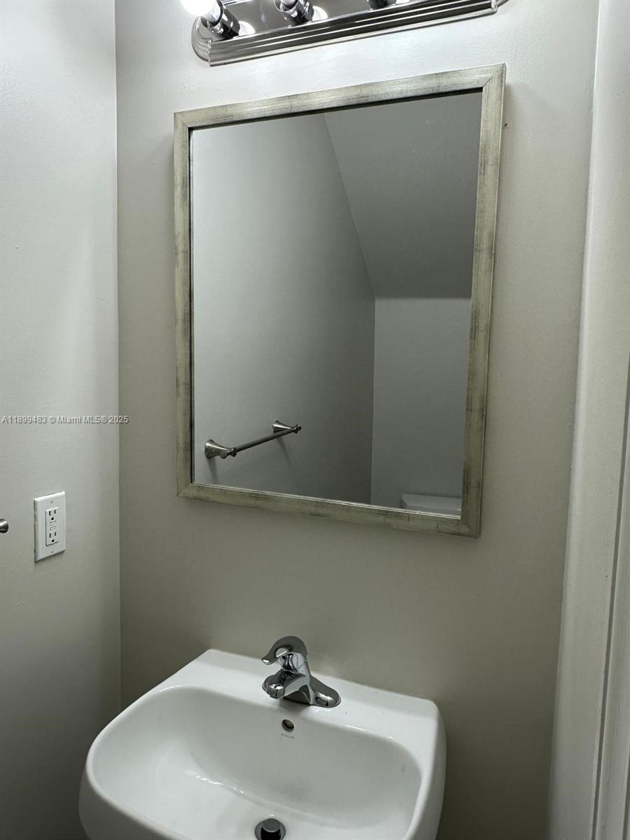2556 Southwest 83rd Avenue, Unit 101 Miramar, FL 33025 - Photo 18 of 19 a bathroom with a sink and mirror