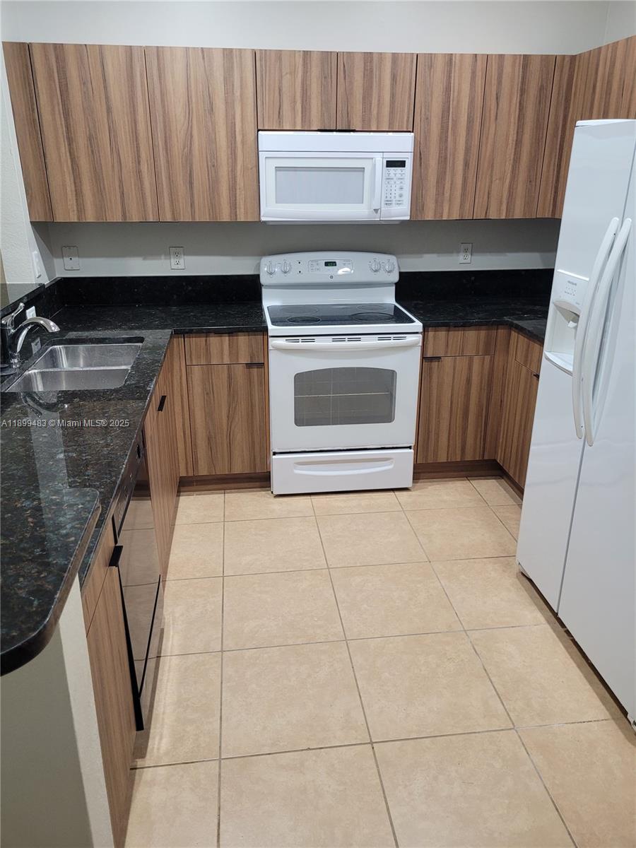 2556 Southwest 83rd Avenue, Unit 101 Miramar, FL 33025 - Photo 5 of 19 a kitchen with a stove and a cabinet