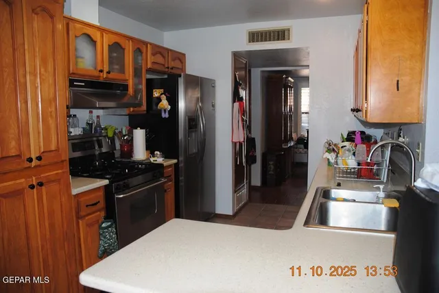 a kitchen with stainless steel appliances granite countertop a refrigerator and a stove