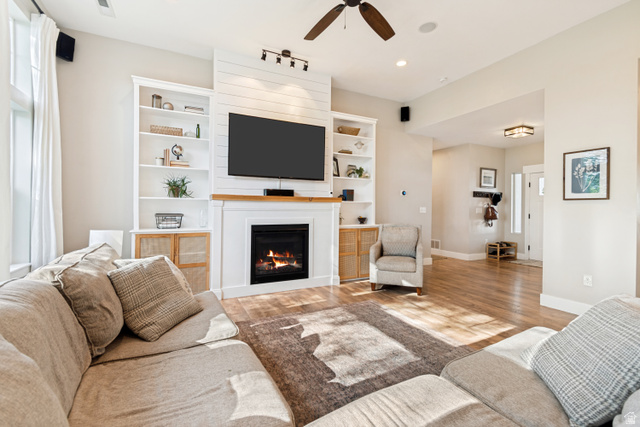 332 South 500 West Payson, UT 84651 - Photo 9 of 50 Living area featuring a fireplace with a wood mantle, shiplap accent wall, built-in shelving, wood style lvp flooring, and recessed lighting