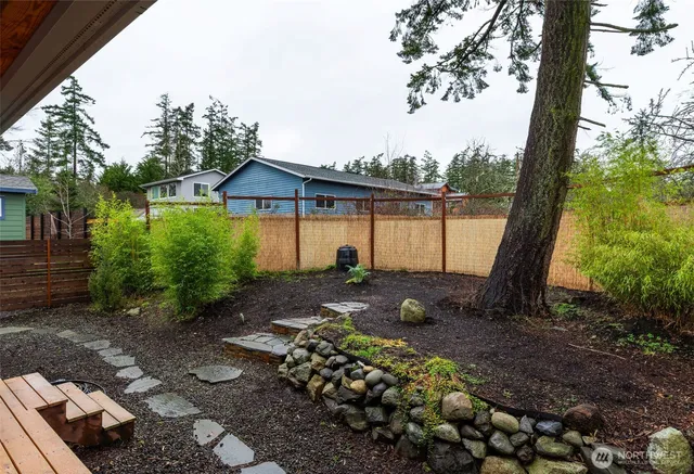 a view of a backyard with plants and lake view