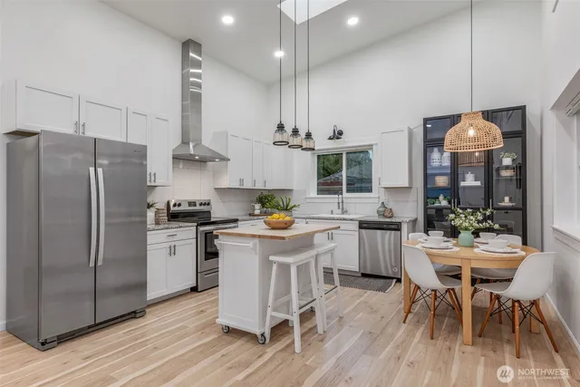 a kitchen with granite countertop white cabinets and white stainless steel appliances