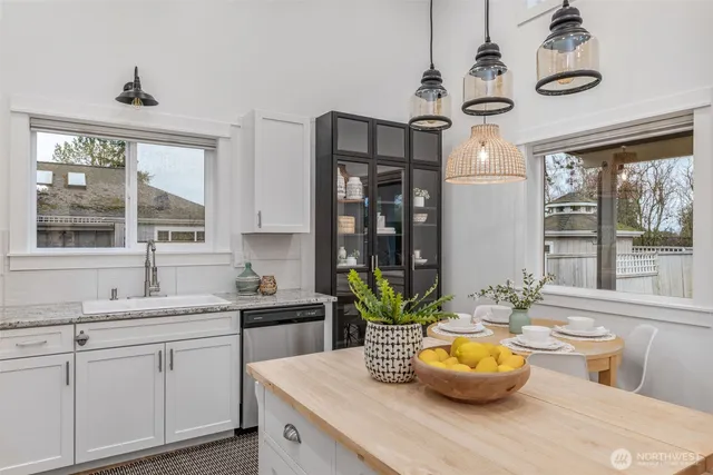 a room with stainless steel appliances kitchen island granite countertop furniture and a rug