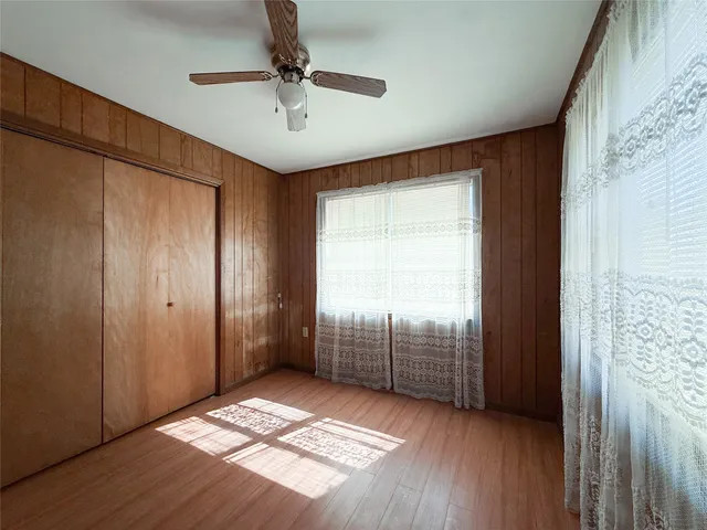 a view of an empty room with cabinet and a window