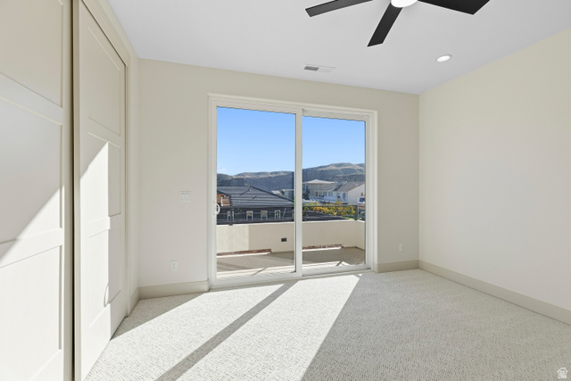 226 East 1100 North Hurricane, UT 84737 - Photo 41 of 49 Unfurnished bedroom featuring light colored carpet, a mountain view, access to outside, and a ceiling fan