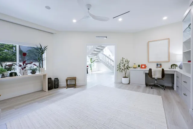 a view of staircase with lots of frames on wall and wooden floor