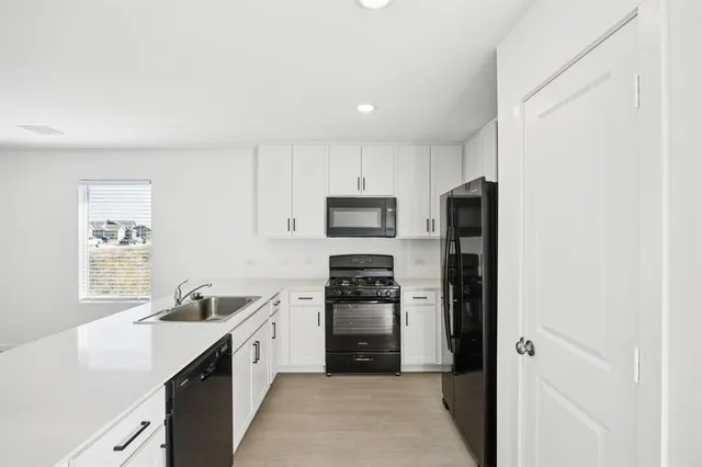 a kitchen with cabinets stainless steel appliances and a counter space