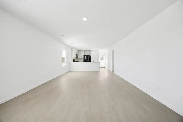 a view of a kitchen with refrigerator and a window