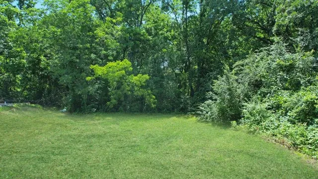 a view of a house with a yard and basketball court