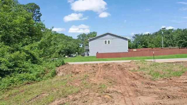 a view of a house with a yard and basketball court