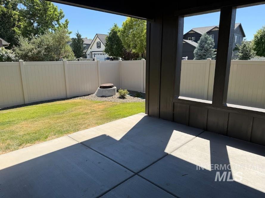 755 West Wrangler Street Meridian, ID 83646 - Photo 27 of 35 Covered concrete patio opening to a fenced backyard with a manicured lawn and a small shrub