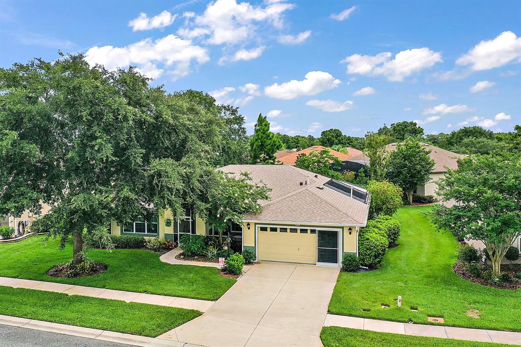 6121 Hunters Ridge Avenue Leesburg, FL 34748 - Photo 1 of 1 Front Exterior with Mature Landscaping, 2-Car Garage and Sidewalk Community