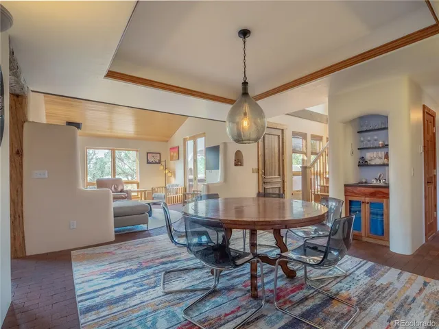 a dining room with furniture a chandelier and wooden floor