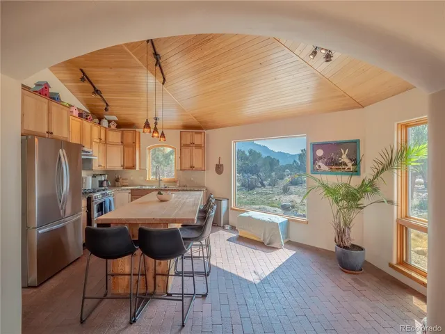 a kitchen with a refrigerator and wooden floor