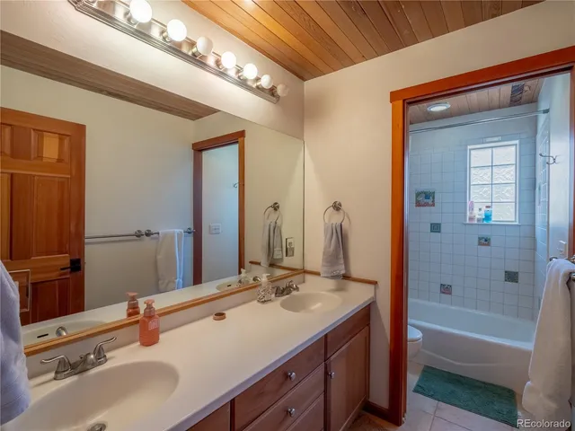 a bathroom with a double vanity sink mirror double and bathtub