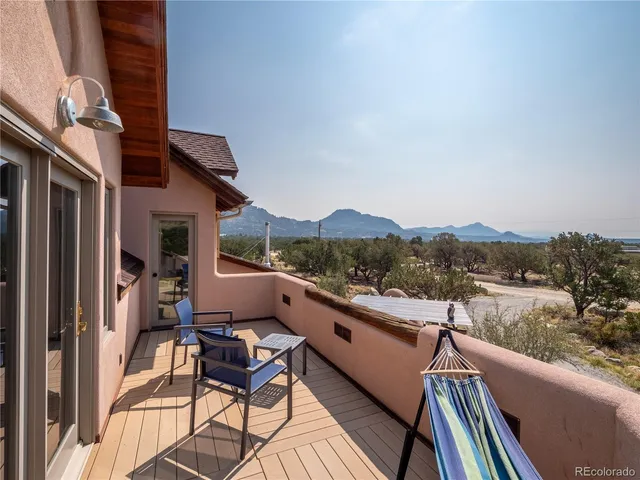 a view of a balcony with chairs and wooden floor