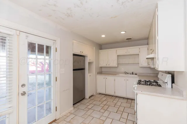 a kitchen with stainless steel appliances granite countertop a refrigerator and a stove top oven