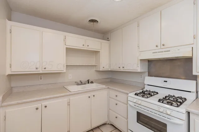 a kitchen with white cabinets and appliances