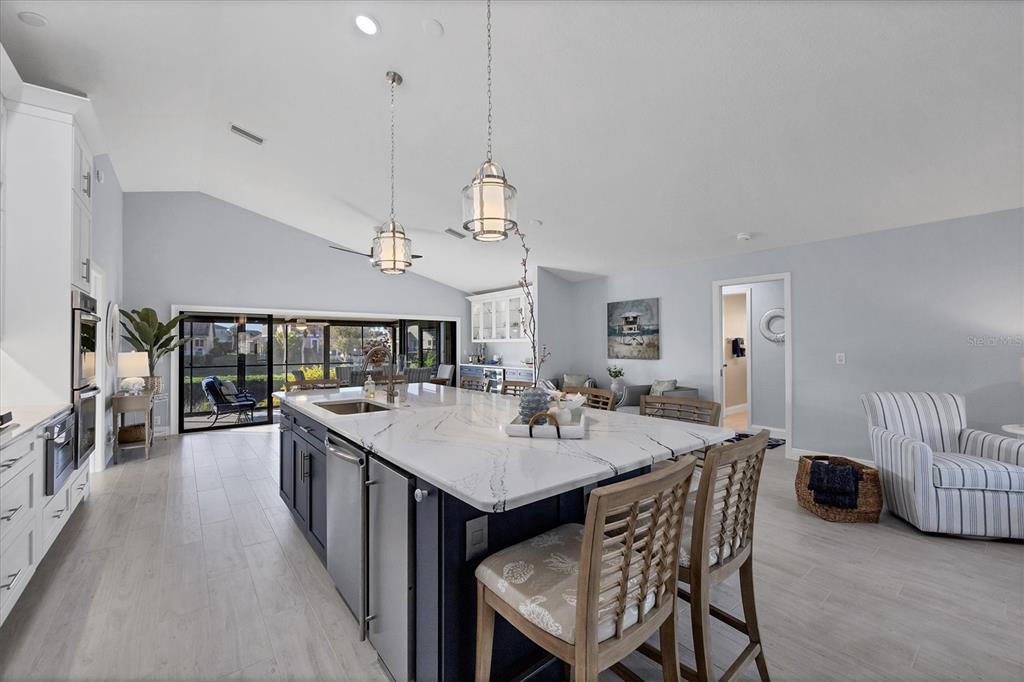 139 Inlets Boulevard, Unit 139 Nokomis, FL 34275 - Photo 11 of 59 a view of a dining room and livingroom with furniture wooden floor a rug a flat screen tv a rug and a chandelier
