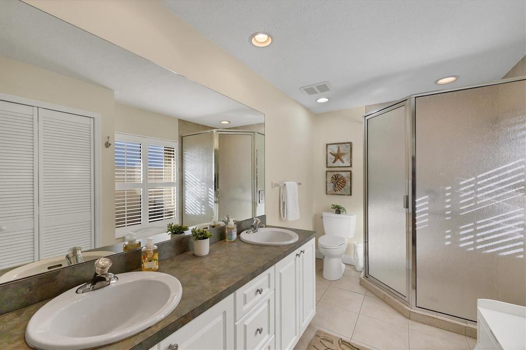 139 Inlets Boulevard, Unit 139 Nokomis, FL 34275 - Photo 15 of 59 a bathroom with a double vanity sink mirror and toilet