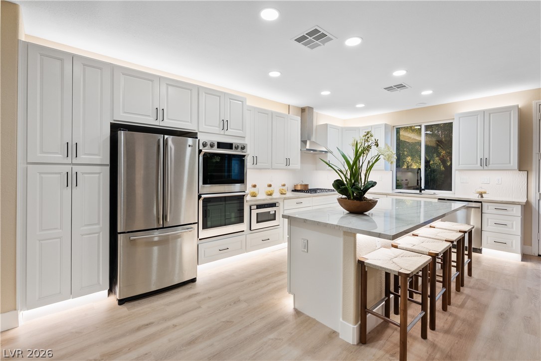 1662 Ravanusa Drive Henderson, NV 89052 - Photo 63 of 74 A well-appointed kitchen showcasing a spacious island with seating and integrated appliances.