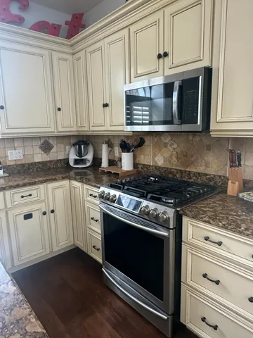 a kitchen with granite countertop white cabinets and appliances